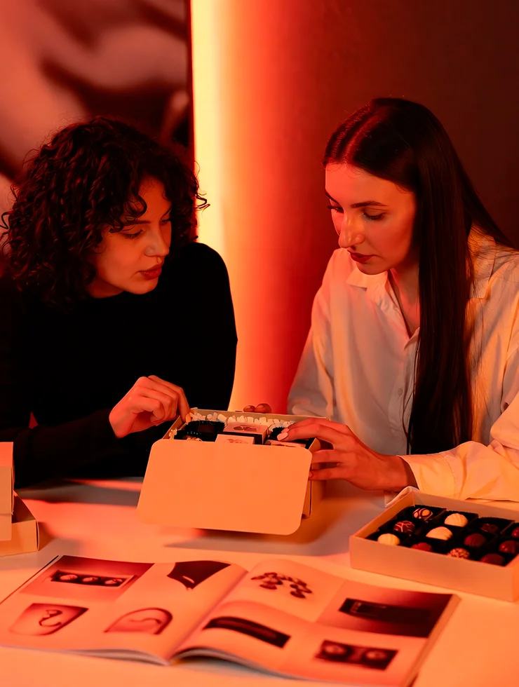 Маркетолог выбирает образцы новогодних корпоративных подарков за столом